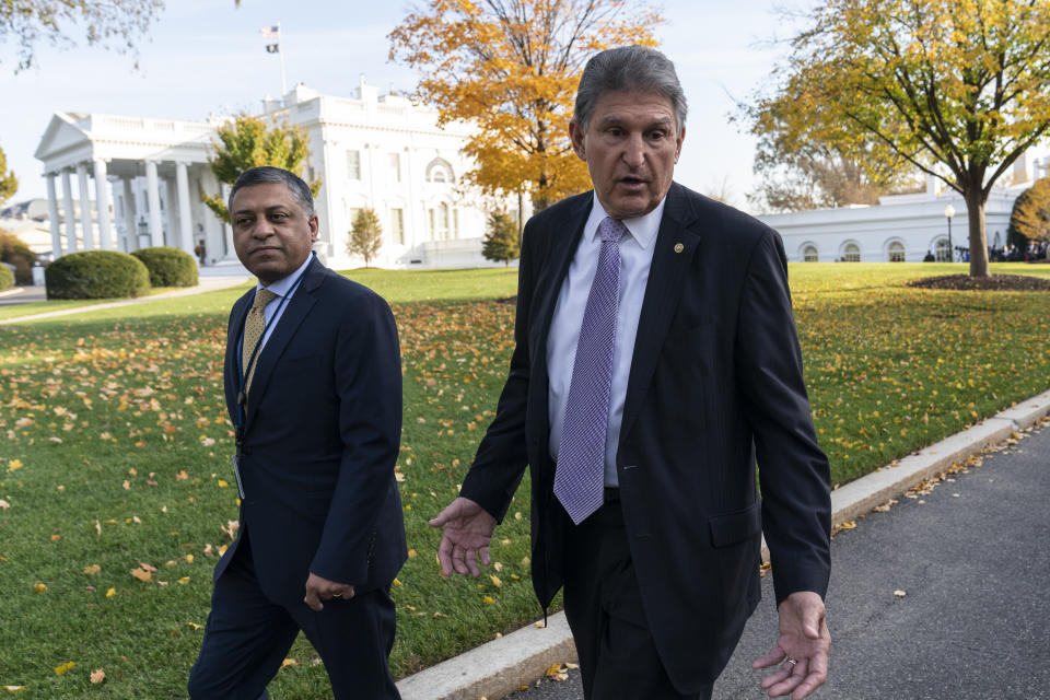 FILE - Dr. Rahul Gupta, left, the director of the White House Office of National Drug Control Policy, walks with Sen. Joe Manchin, D-W.Va., at the White House, Nov. 18, 2021, in Washington. President Joe Biden tried to strike a deal on a sweeping social spending and climate package with Manchin, until the conservative Democrat abruptly pulled the plug on the talks in a Fox News interview. Manchin would later pick up the negotiations again, this time with just Senate Majority Leader Chuck Schumer, D-N.Y. (AP Photo/Alex Brandon, File)