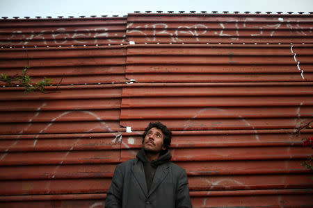 Joaquin, 36, a chef from Guatemala who says he was deported from the United States, poses for a photograph while leaning on a section of the border fence separating Mexico and the United States, in Tijuana, Mexico, February 26, 2017. REUTERS/Edgard Garrido