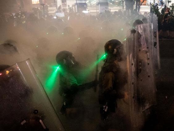 Police move forward through tear gas as they clash with protesters (Chris McGrath/Getty Images)