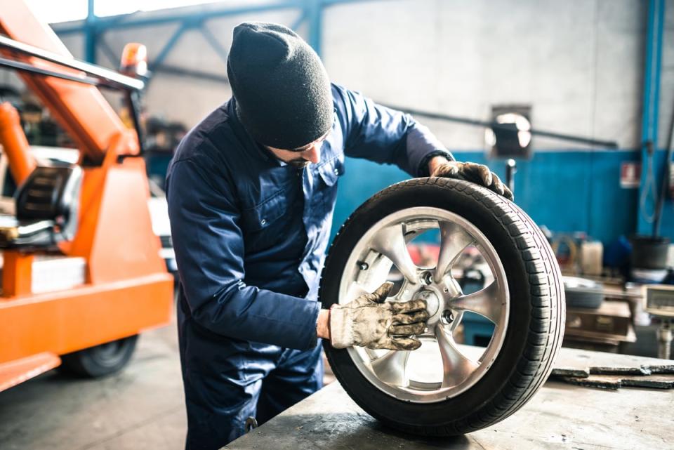 A person working on a tire in a shop.