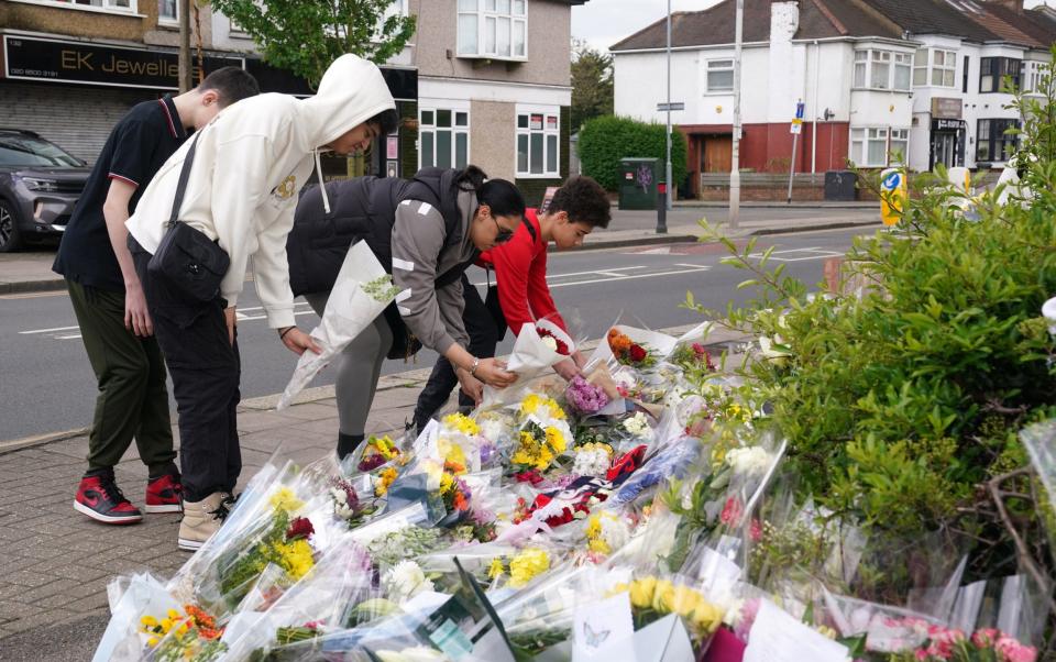 Young people add their flowers to the many tributes left for Daniel
