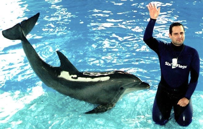 Former Sea World trainer Nico Maragos waves to the crowd during a dolphin show at Sea World.