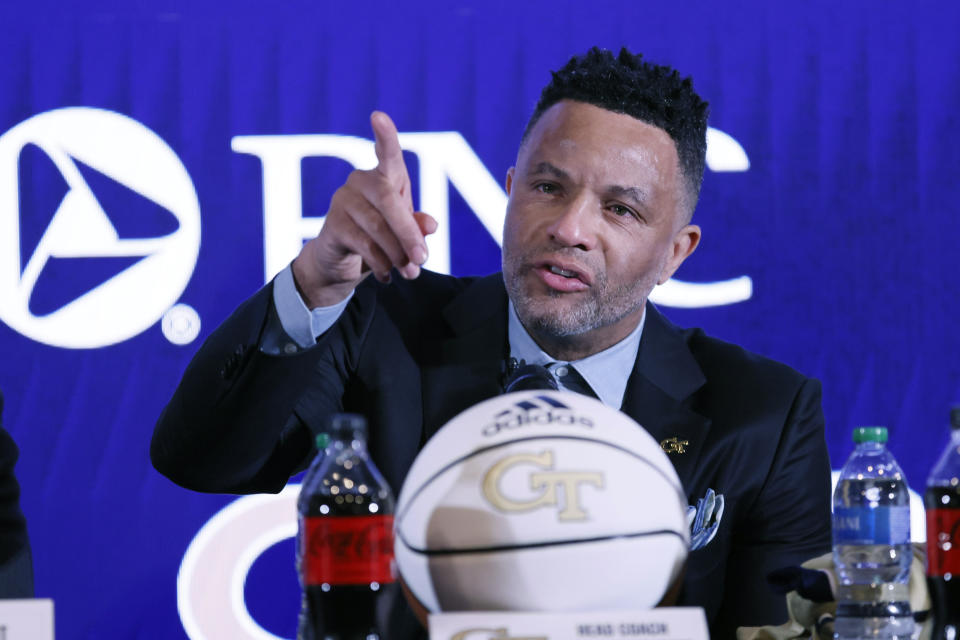 FILE - With tears in his eyes, Damon Stoudamire points to acknowledge the presence of his sons Brandon and Damon Stoudamarie Jr. at a press conference where he was introduced as the new Georgia Tech NCAA college basketball head coach in Atlanta, Tuesday, March 14, 2023. Damon Stoudamire is hoping to succeed where three others failed before him. Once a powerhouse in the college basketball world, Georgia Tech has struggled for nearly two decades to become relevant again. (Miguel Martinez/Atlanta Journal-Constitution via AP, File)