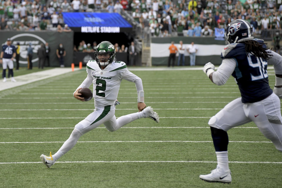 New York Jets quarterback Zach Wilson (2) runs the ball against Tennessee Titans defensive end Denico Autry (96) during overtime of an NFL football game, Sunday, Oct. 3, 2021, in East Rutherford, N.J. (AP Photo/Bill Kostroun)