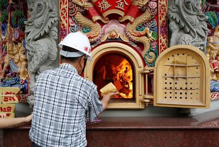 Lin Fu-chun, CEO of Chuanso factory, that manufactures temples and other religious objects, burns Chinese paper offerings used to pay respects to the deceased and gods, in Pingtung, Taiwan July 5, 2016. REUTERS/Tyrone Siu