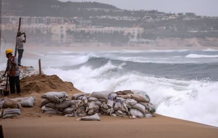 Workers are pictured at La Medano beach in Cabo San Lucas as Hurricane Lorena churns close to the southern tip of Mexico's Baja California