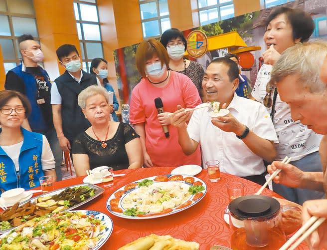 新北市社會局18日表揚123處績優共餐單位，新北市長侯友宜也與現場長者共享美食。（葉德正攝）