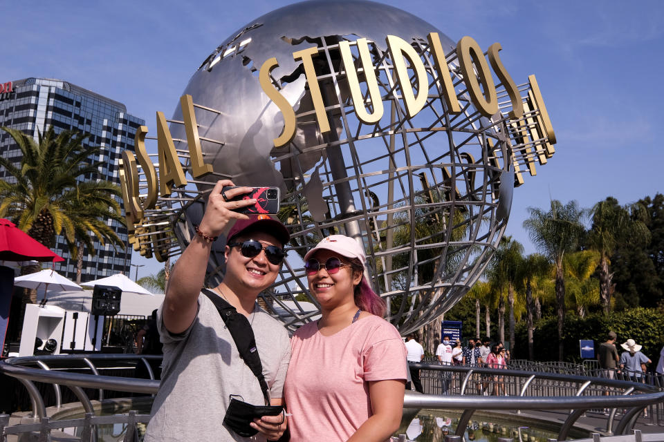 People take photos at Universal Studios in Universal City, Calif., Tuesday, June 15, 2021. On Tuesday, California lifted most of its COVID-19 restrictions and ushered in what has been billed as the state’s “Grand Reopening.” (AP Photo/Ringo H.W. Chiu)