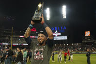 Atlanta Braves left fielder Eddie Rosario holds the Most Valuable Player trophy after winning Game 6 of baseball's National League Championship Series against the Los Angeles Dodgers Sunday, Oct. 24, 2021, in Atlanta. The Braves defeated the Dodgers 4-2 to win the series. (AP Photo/Brynn Anderson)