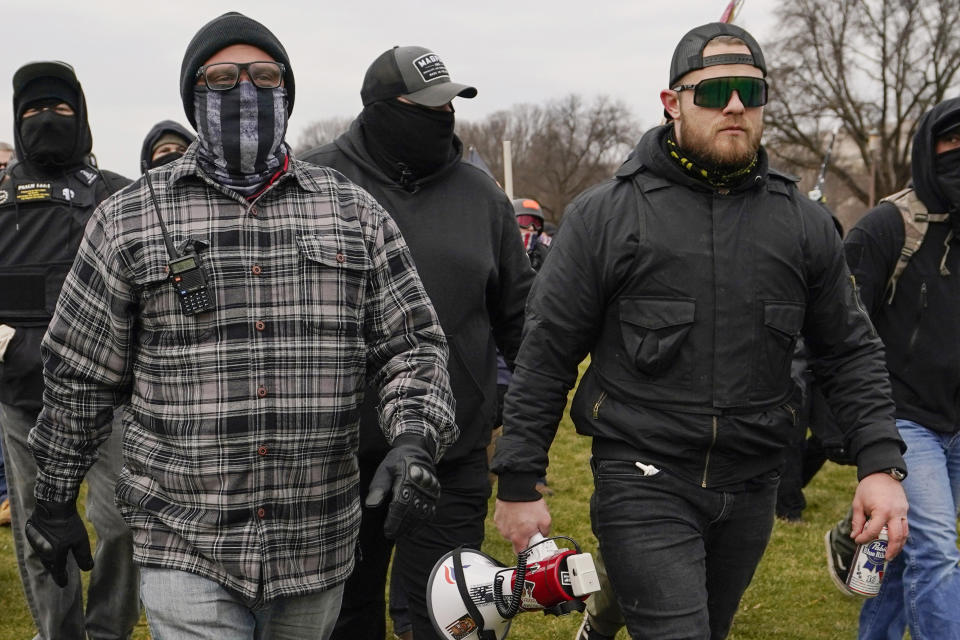 FILE - Proud Boys members Joseph Biggs, left, and Ethan Nordean, right with megaphone, walk toward the U.S. Capitol in Washington, Jan. 6, 2021. Former Proud Boys leader Enrique Tarrio and three other members of the far-right extremist group have been convicted of a plot to attack the U.S. Capitol in a desperate bid to keep Donald Trump in power after Trump lost the 2020 presidential election. (AP Photo/Carolyn Kaster, File)