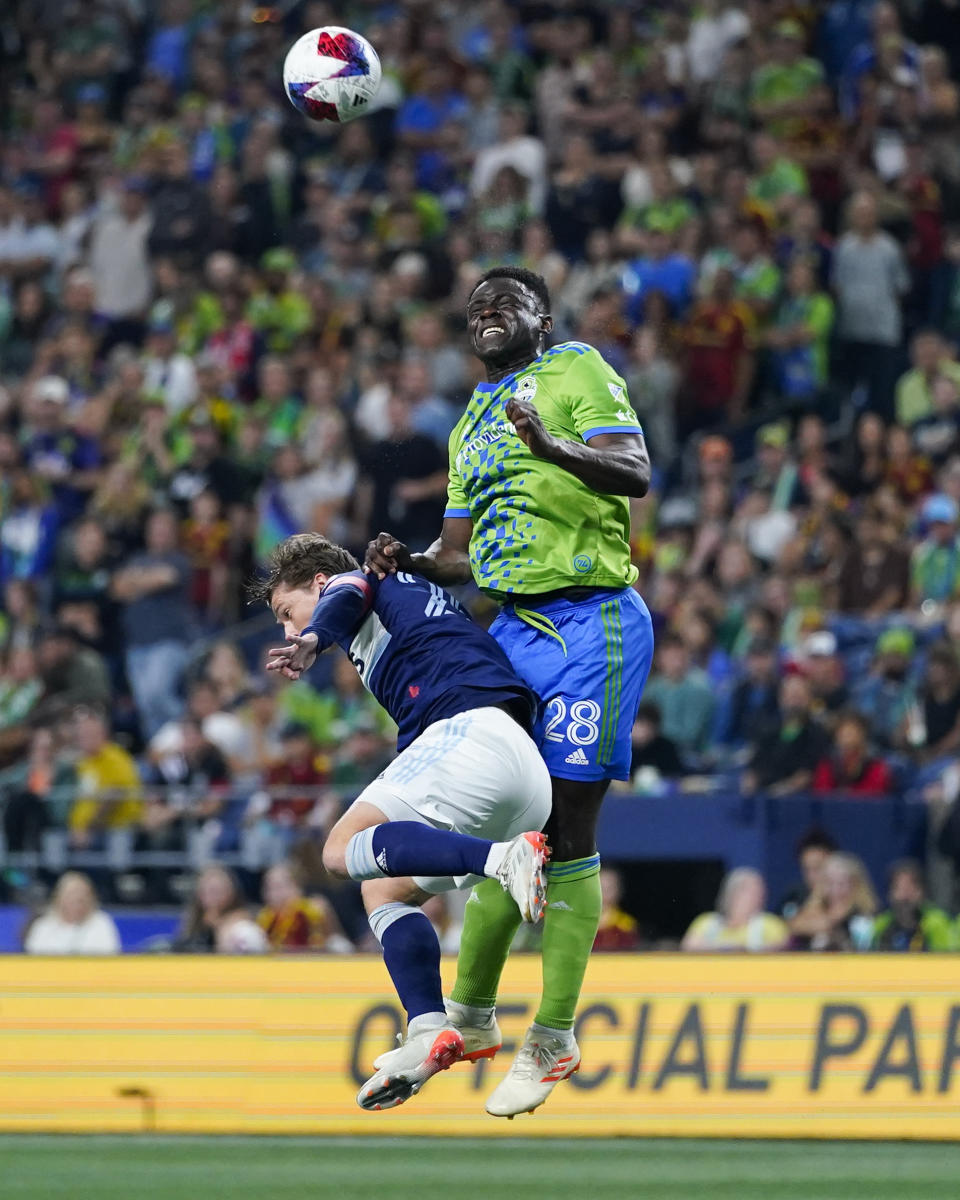 Vancouver Whitecaps midfielder Ryan Gauld, left, and Seattle Sounders defender Yeimar Gómez try to head the ball during the first half of an MLS soccer match Saturday, Oct. 7, 2023, in Seattle. (AP Photo/Lindsey Wasson)