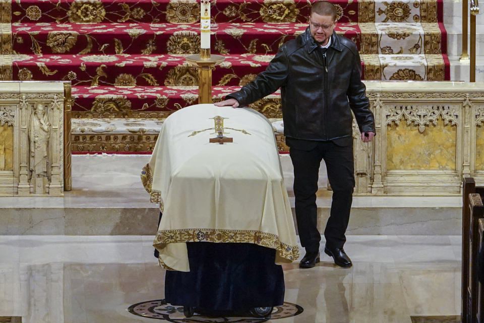 New York City Police Officer Jason Rivera's brother touches his casket after eulogizing him during his funeral mass, Friday, Jan. 28, 2022, at St. Patrick's Cathedral in New York. (AP Photo/Mary Altaffer, Pool)