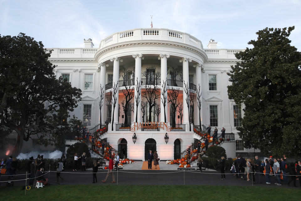 President Donald Trump and first lady Melania Trump give candy to children during a Halloween trick-or-treat event on the South Lawn of the White House which is decorated for Halloween, Monday, Oct. 28, 2019, in Washington. (AP Photo/Alex Brandon)