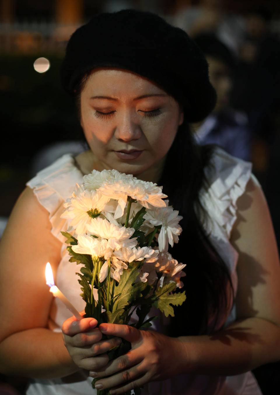 A woman holds a flower and candles during a ceremony for the passengers on board the missing Malaysia Airlines flight MH370 in Kuala Lumpur, Malaysia, Sunday March 30, 2014. A new batch of relatives from China has arrived today to seek answers of what happened to their loved ones on board flight MH370. (AP Photo/Aaron Favila)