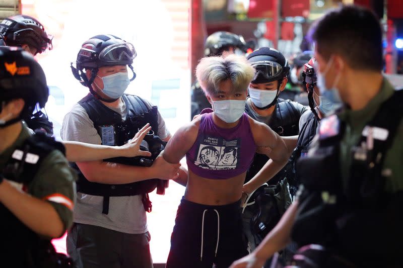 Riot police detain a man during a protest oppose postponed elections, in Hong Kong