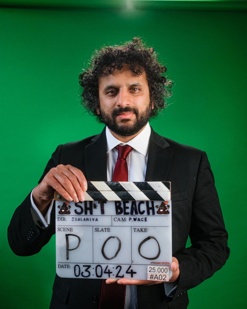Nish Kumar holds up clapper board for Sh*t Beach film (