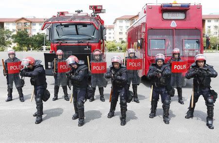 Malaysia's public order police, the Federal Reserve Unit (FRU), pose for photographs wearing riot control equipment at their headquarters in Kuala Lumpur November 20, 2014. REUTERS/Olivia Harris