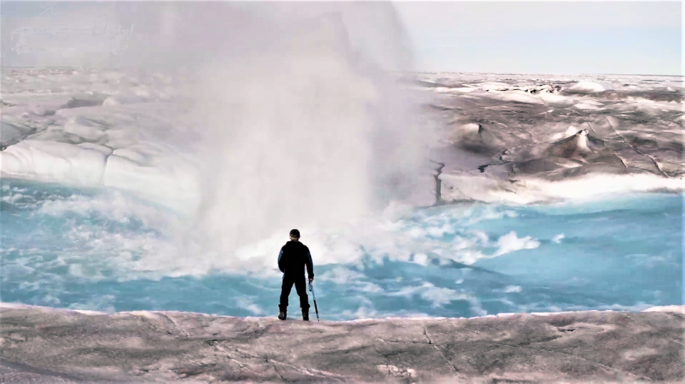 Alun Hubbard stands beside a moulin forming in a meltwater stream on the Greenland ice sheet. Courtesy of Alun Hubbard