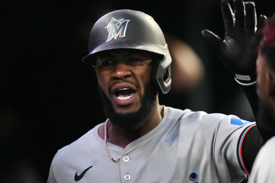 Miami Marlins' Bryan De La Cruz is greeted in the dugout after scoring during the tenth inning of a baseball game against the Detroit Tigers, Tuesday, May 14, 2024, in Detroit. (AP Photo/Carlos Osorio)