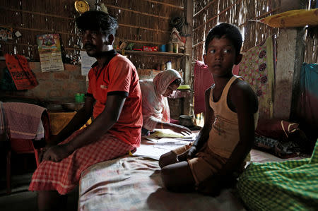 Riyazul Haq (L) and his son Sahil Shaikh (R) whose names are excluded from the draft list of the National Register of Citizens (NRC), sit inside their house as Haq's wife checks the NRC documents in Dhubri district, in the northeastern state of Assam, India August 3, 2018. REUTERS/Adnan Abidi