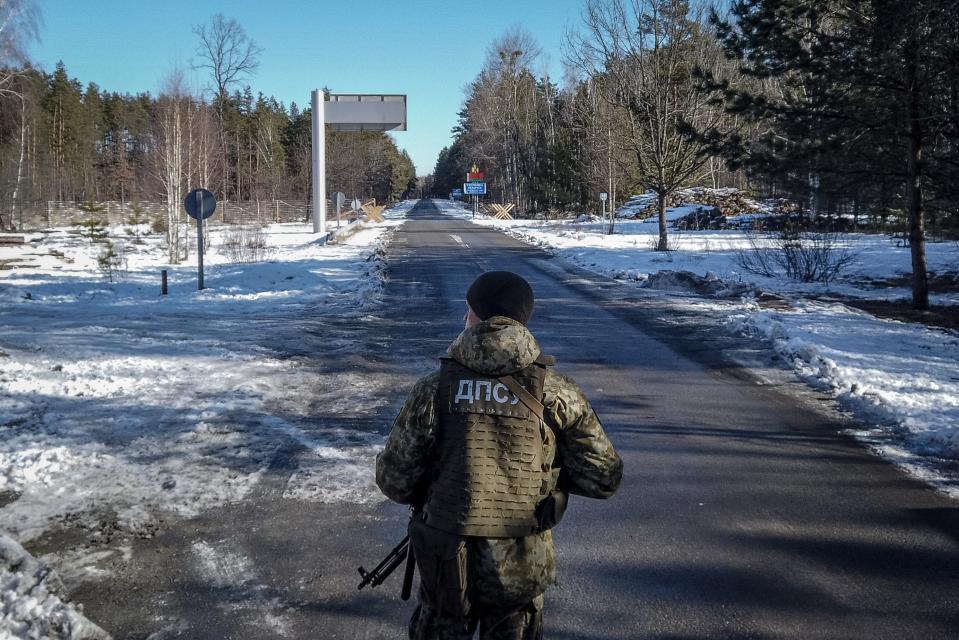 A member of the Ukrainian State Border Guard stands watch at the border crossing between Ukraine and Belarus on Feb. 13, 2022, in Vilcha, Ukraine. Russian forces are conducting large-scale military exercises in Belarus, across Ukraine's northern border, amid a tense diplomatic standoff between Russia and Ukraine's Western allies.