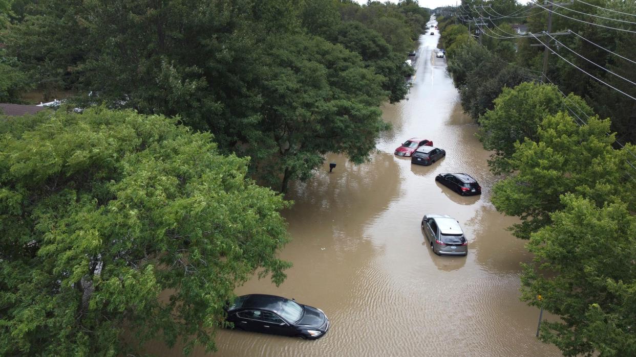 After hammering rains, a residential street near Sheldon Road at Ford Road in Canton is flooded stranding five cars on Thursday, Aug. 24, 2023.