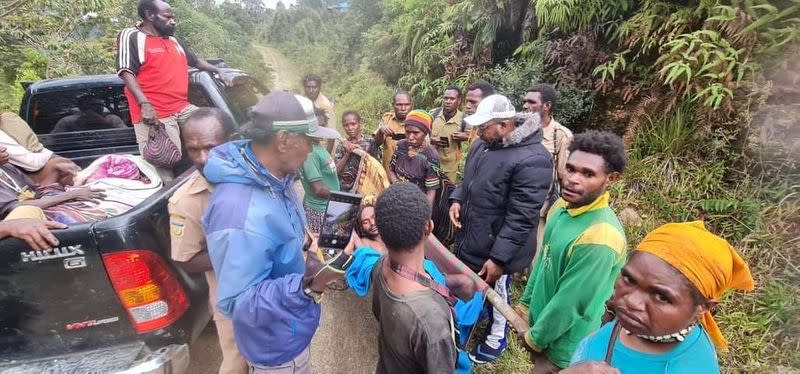 Bagau is carried by his two brothers, among others, on his way to the local health clinic in Intan Jaya regency, Papua