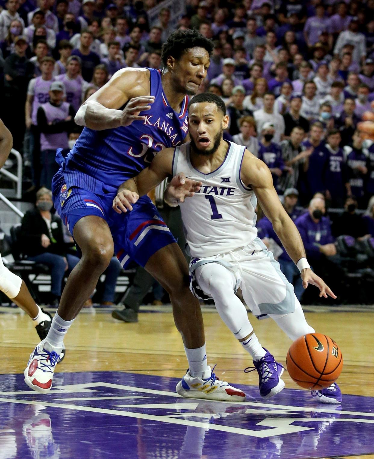 Kansas State guard Markquis Nowell (1) drives to the basket against Kansas' David McCormack (33) during Saturday's game at Bramlage Coliseum.