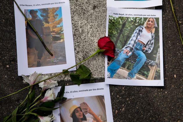 Pictures of victims of police violence in Iran are placed with flowers on the ground during a protest over Amini's death outside the Iranian Embassy in Madrid on Wednesday. (Photo: Pablo Blazquez Dominguez via Getty Images)