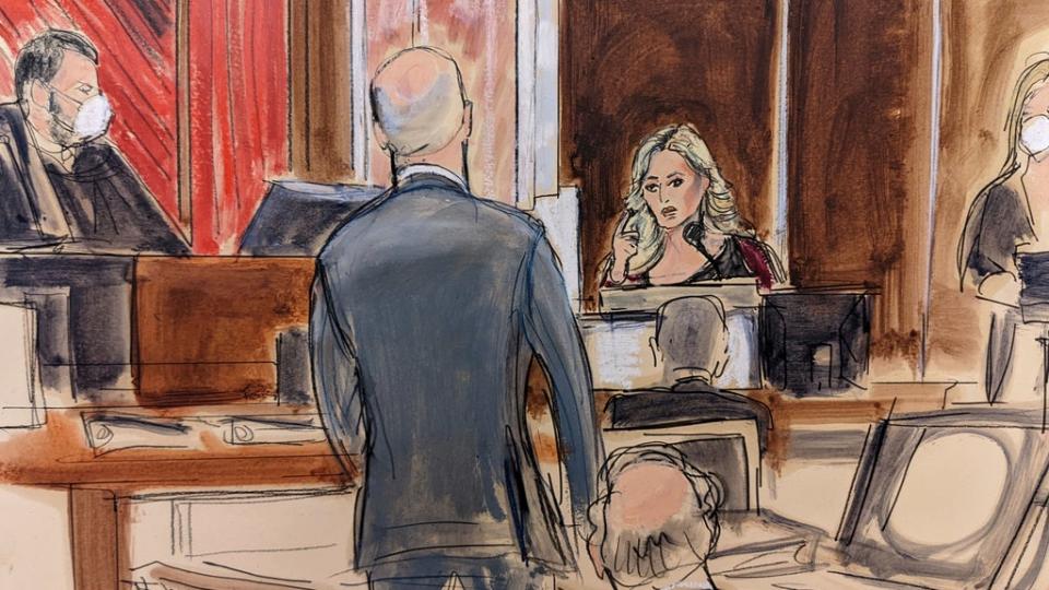Stormy Daniels testifying on the witness stand, at right, points to Michael Avenatti, standing at center. Judge Jesse Furman presides on the bench (AP)