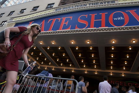 A woman passes by as people line up for "The Late Show with Stephen Colbert" at the Ed Sullivan Theater in Manhattan, New York, September 8, 2015. REUTERS/Brendan McDermid