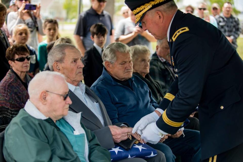 Maj. Gen. Michael Garshak, right, Idaho’s adjutant general and commander of the state’s National Guard, presented Wilber Bridger, center, Pfc. Kenneth Bridger’s brother and oldest surviving relative, the U.S. flag and the Purple Heart on his brother’s behalf. Bridger’s brothers Lynn and Halbert “Lee” Bridger along with his sister, Florence Fiscus, also received the U.S. flag from the Idaho National Guard during the military honors ceremony on May 21, 2022 in Twin Falls, Idaho, 72 years after Pfc. Bridger went missing in the Korean War.