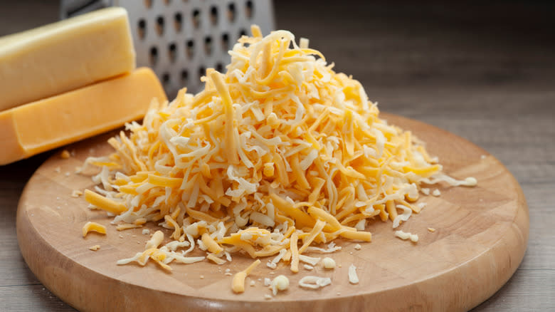 pile of grated cheese on wooden block