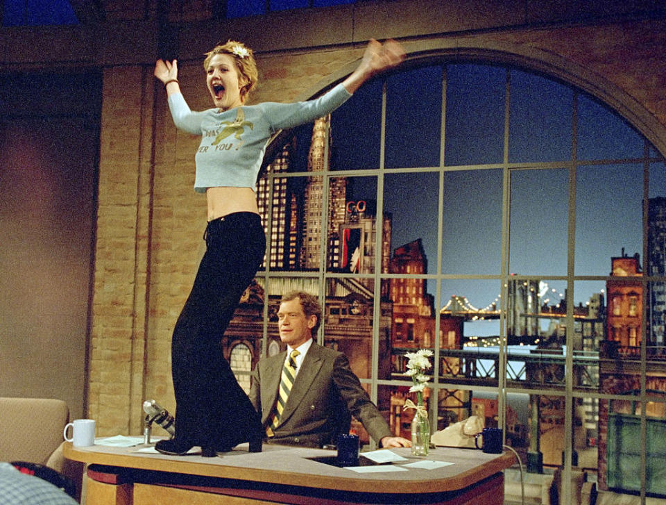 Drew Barrymore jumps on David Letterman's desk on his show, expressing excitement