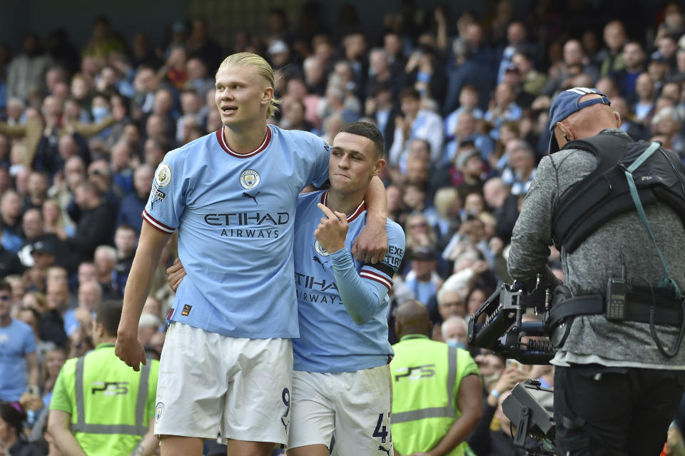 Manchester City's Phil Foden, right, celebrates with his teammate Erling Haaland after scoring his side's sixth goal and his personal hat trick during the English Premier League soccer match between Manchester City and Manchester United at Etihad stadium in Manchester, England, Sunday, Oct. 2, 2022. (AP Photo/Rui Vieira)