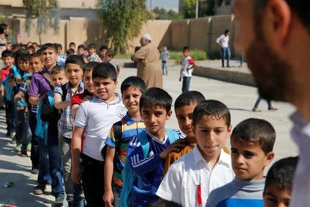 Schoolchildren stand in a line to attend their class at school in eastern Mosul, Iraq April 20, 2017. Picture taken April 20, 2017. REUTERS/ Muhammad Hamed