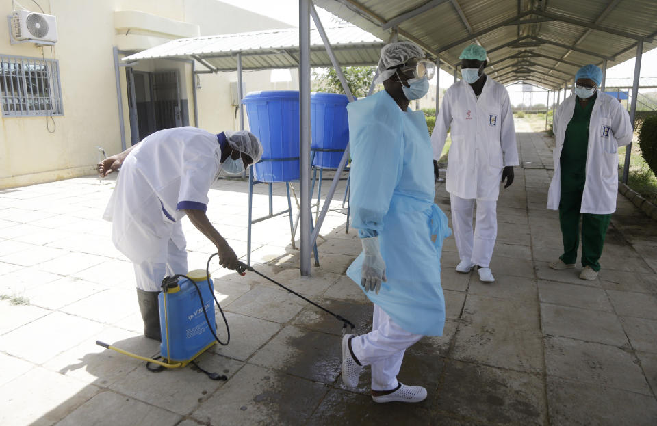 Medical personnel spray disinfectant outside the ward where COVID-19 patients are receiving treatment, at the Farcha provincial hospital in N'Djamena, Chad, Friday April 30, 2021. While the world's wealthier nations have stockpiled coronavirus vaccines for their citizens, many poorer countries are scrambling to secure enough doses, and some, like Chad, have yet to receive any. (AP Photo/Sunday Alamba)