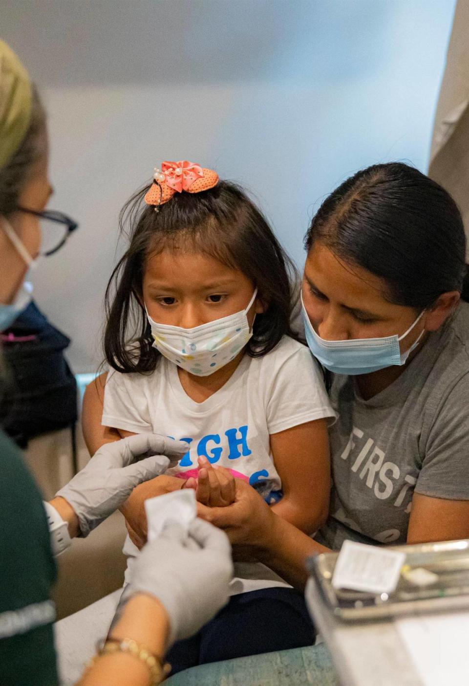 Saory Betalleluz, de cinco años, se sienta con su madre, Julie Machaca, mientras recibe una vacuna en Pediatric Mobile Clinic de UM en Homestead el viernes 24 de junio de 2022. A partir del lunes 27 de junio de 2022, los niños menores de cinco años podrán recibir la vacuna COVID-19 en este lugar.