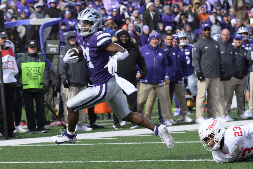 Kansas State running back DJ Giddens (31) escapes a tackle by Houston defensive back Isaiah Hamilton (23) and runs in for a touchdown during the second half of an NCAA college football game in Manhattan, Kan., Saturday, Oct. 28, 2023. (AP Photo/Reed Hoffmann)