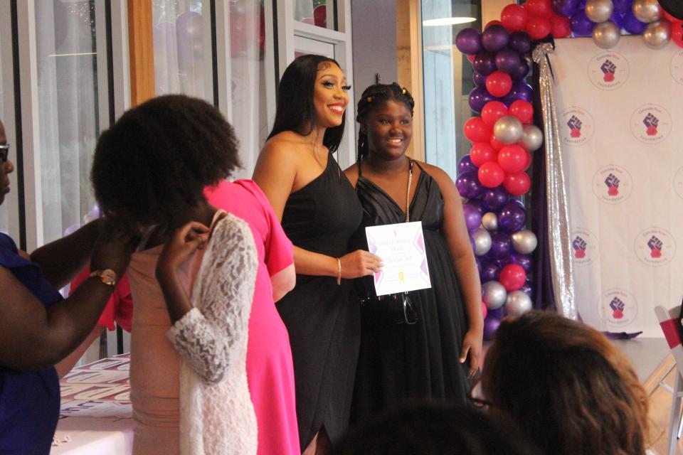 Ashely McClellan Robinson, left, poses with Ty’Niyah Smart, right, during the Concrete Rose Foundation's pinning and award ceremony.
(Credit: Photo by Voleer Thomas/For The Guardian)