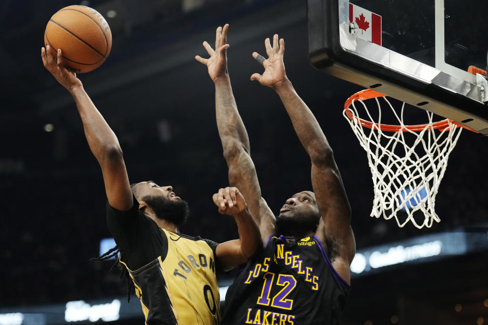 Toronto Raptors guard Javon Freeman-Liberty (0) drives to the basket as Los Angeles Lakers forward Taurean Prince (12) defends during the first half of an NBA basketball game Tuesday, April 2, 2024, in Toronto. (Frank Gunn/The Canadian Press via AP)