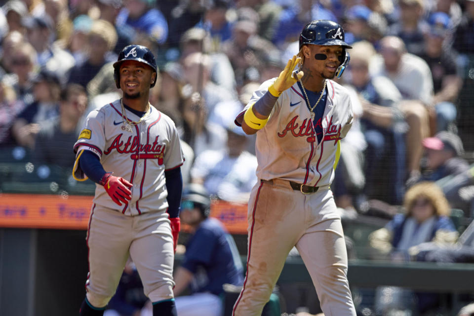 Atlanta Braves' Ronald Acuña Jr., right, leads Orlando Arcia to the dugout after scoring on a triple by Austin Riley against the Seattle Mariners during the fourth inning of a baseball game, Wednesday, May 1, 2024, in Seattle. (AP Photo/John Froschauer)