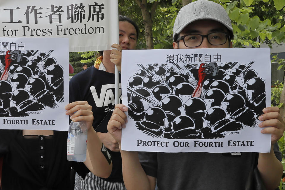 Journalists hold placards during a silent march to police and government headquarters in Hong Kong, Sunday, July 14, 2019, demanding police to stop assaulting journalists and obstructing reporting. (AP Photo/Kin Cheung)