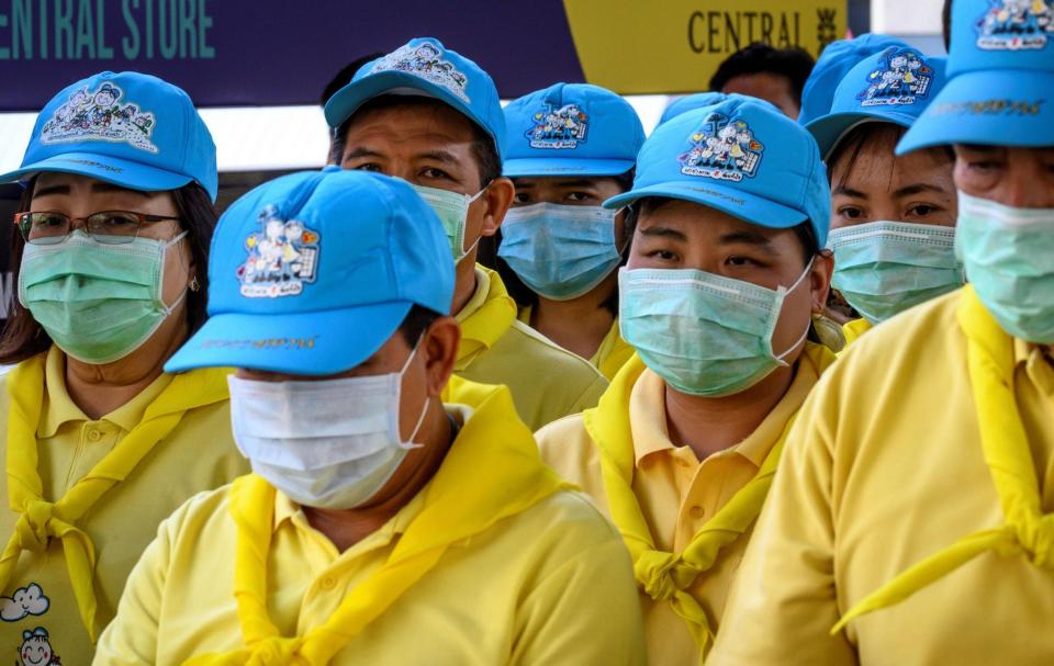 Volunteers wearing protective facemasks (AFP via Getty Images)