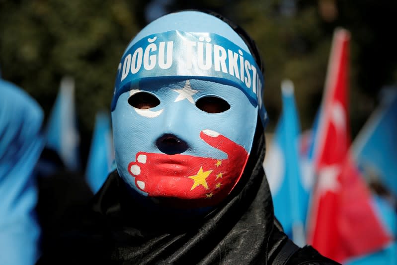 FILE PHOTO: An ethnic Uighur demonstrator wears a mask as she attends a protest against China in front of the Chinese Consulate in Istanbul