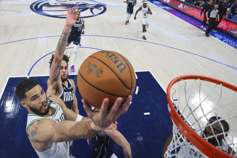 Boston Celtics forward Jayson Tatum, left, goes up for a basket against Dallas Mavericks center Dereck Lively II during the first half in Game 3 of the NBA basketball finals, Wednesday, June 12, 2024, in Dallas. The Celtics won 106-99. (Stacy Revere/Pool Photo via AP)