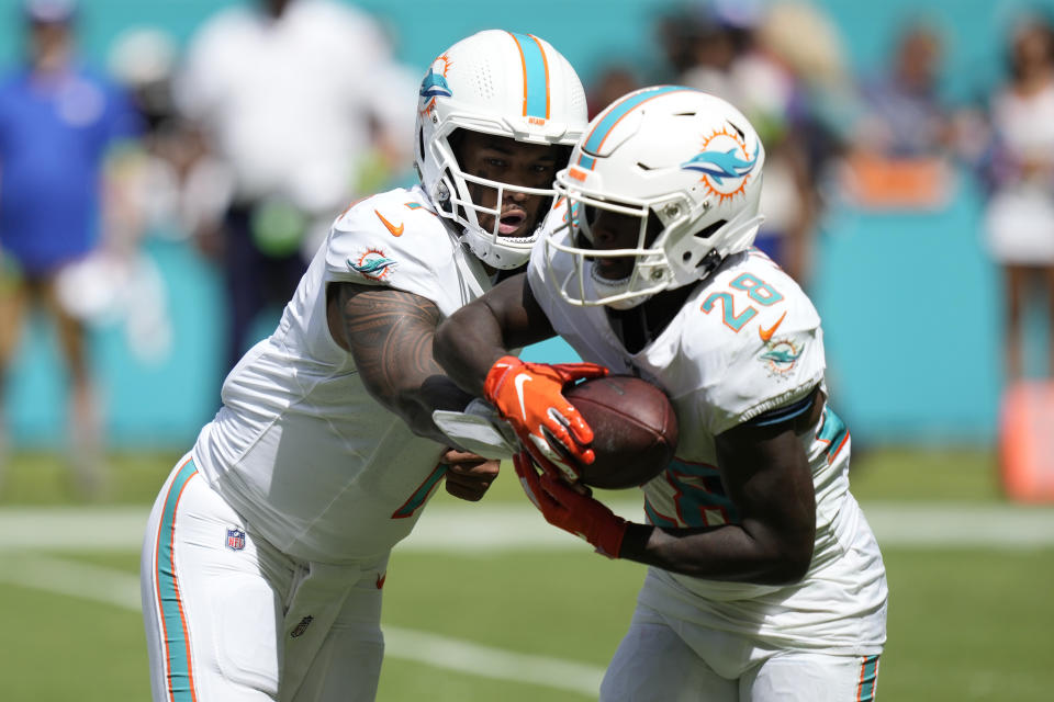 Miami Dolphins quarterback Tua Tagovailoa (1) hands the ball to running back De'Von Achane (28) during the first half of an NFL football game against the New York Giants, Sunday, Oct. 8, 2023, in Miami Gardens, Fla. (AP Photo/Rebecca Blackwell)