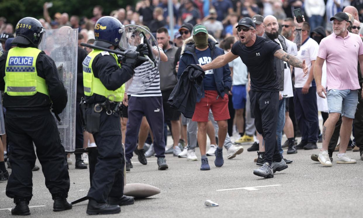 <span>Riot police facing disturbances outside a Holiday Inn Express in Rotherham on Sunday.</span><span>Photograph: Christopher Furlong/Getty Images</span>