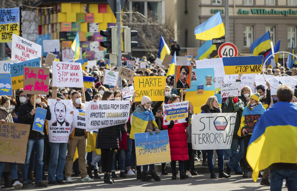 Numerous people demonstrate with signs and flags on Wilhelmsplatz in Stuttgart, Germany, against Russia's military deployment in Ukraine on Saturday, Feb. 26, 2022. (Christoph Schmidt/dpa via AP)