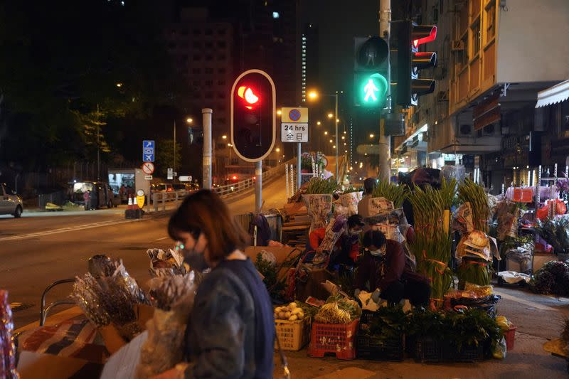 Farmer sells flowers next to traffic lights on the road in Hong Kong